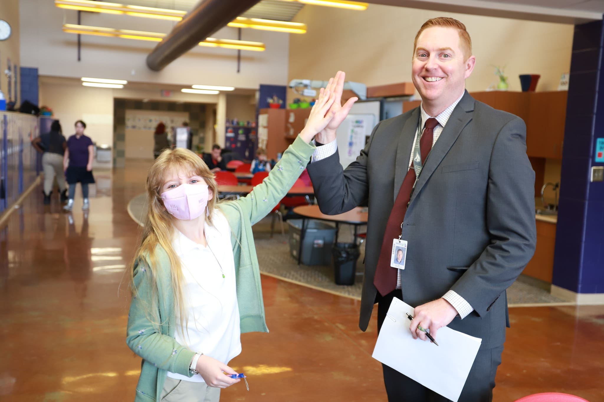 Lou Henry 6 Student giving a high five to a principal in the school hallway